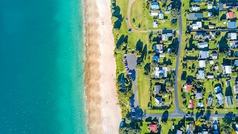 Aerial View Of A Small Suburb Next To A Sunny Beach By The Ocean  Coromandel Peninsula New Zealand Gettyimages 821756102