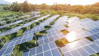 Photo depicts Solar Power Station in the green spring Nature,Solar panel Clean energy thailand