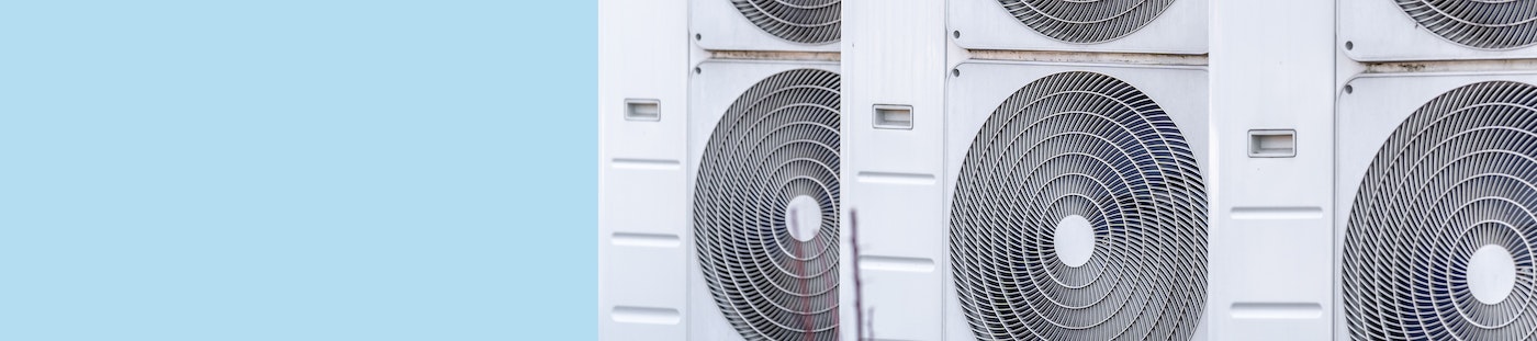 Photo shows three heat pumps on a blue background
